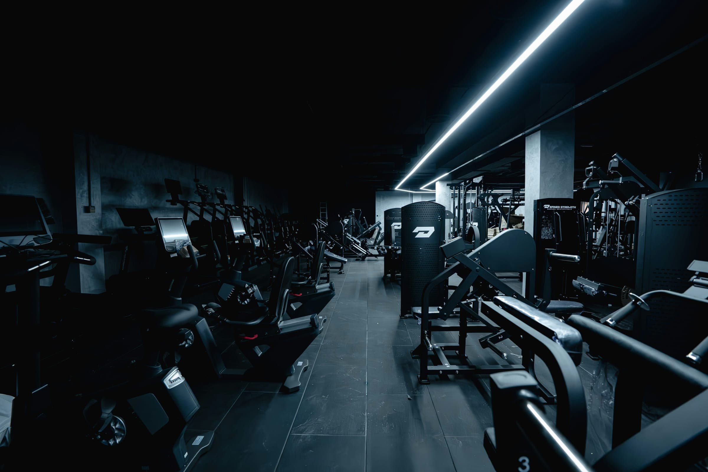 Dark gym interior lit by a single LED strip