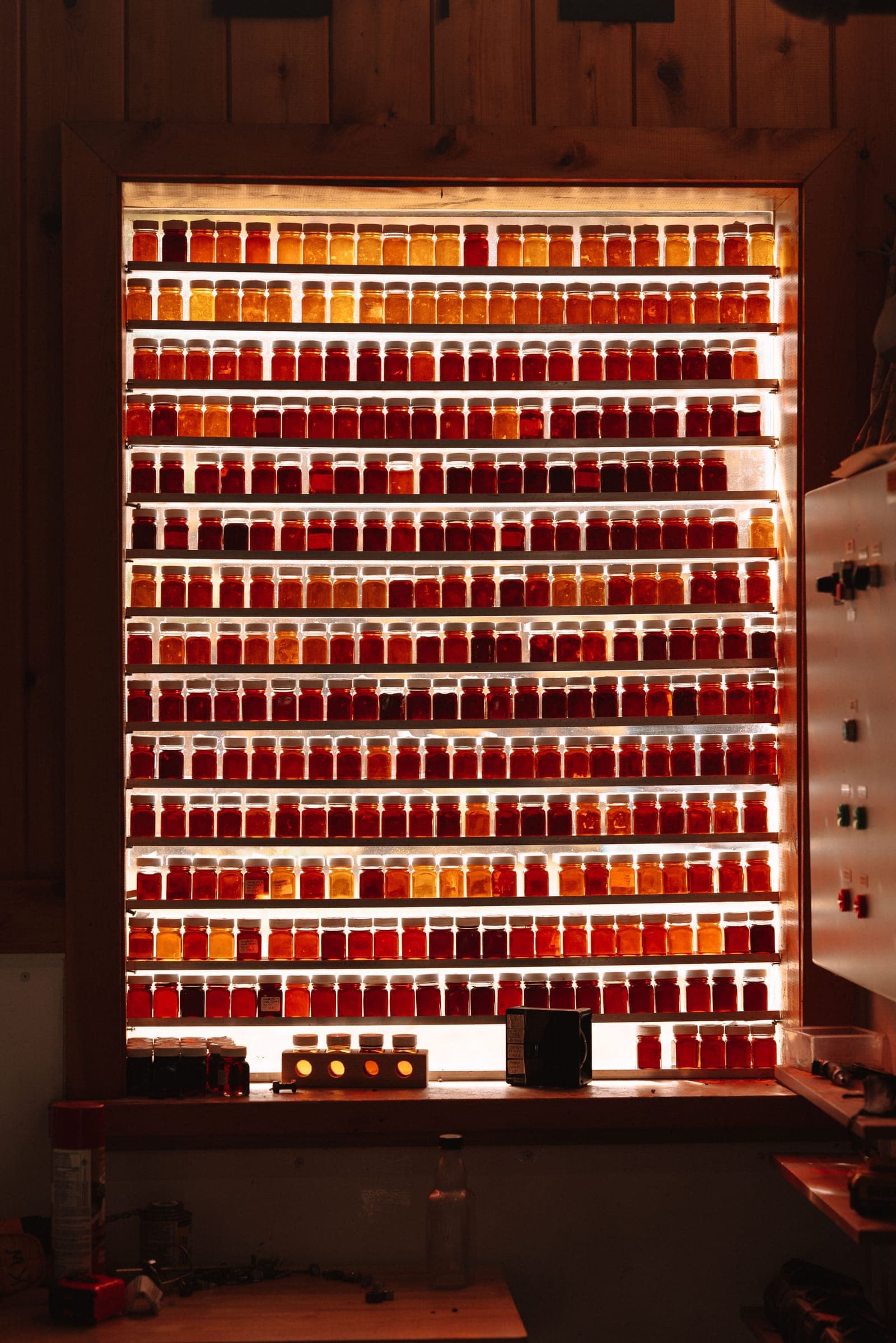 Backlit retail shelving wall lined with amber jars